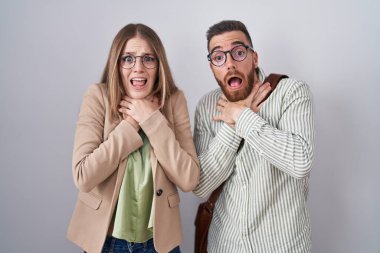 Beyaz arka planda duran genç çift boğularak can çekiştiği için bağırıyor ve boğuluyor. Sağlık problemi. Boğulma ve intihar konsepti. 