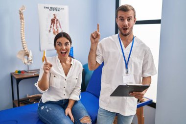 Fizyoterapist randevusundaki genç İspanyol kadın başarılı bir fikirle işaret ediyor. Heyecanlı ve mutlu. Bir numara.. 