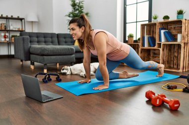 Evde karın kası egzersizi dersi alan kendine güvenen genç bir kadın.