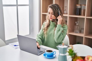 Evde çalışan genç kadın çağrı merkezi ajanı.