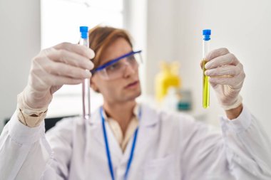 Kafkasyalı genç bilim adamı laboratuarda test tüpleri tutuyor.