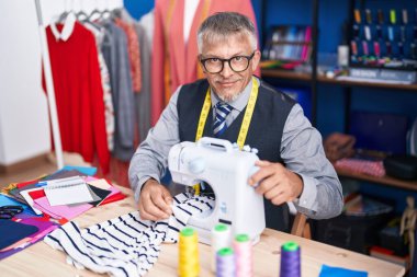 Orta yaşlı, gri saçlı, terzi. Giysi fabrikasında dikiş makinesi kullandığından emin.