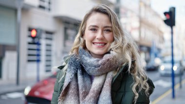 Sokakta kendine güvenen genç sarışın kadın gülümsüyor