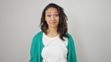 İzole edilmiş beyaz arka planda üzgün bir ifadeyle duran genç, güzel İspanyol kadın.