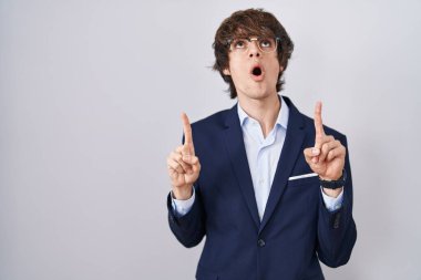 İspanyol iş adamı gözlüklü genç adam şaşırdı ve şaşırdı yukarı baktı ve parmaklarıyla işaret etti ve kollarını kaldırdı. 