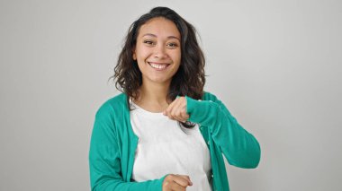 Genç, güzel İspanyol bir kadın, gülümsüyor, kendinden emin, soyutlanmış beyaz arka planda dans ediyor.