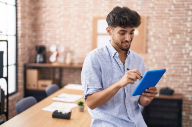 Young arab man business worker writing on touchpad at office