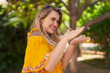 Kendine güvenen genç bir kadın parkta para harcıyor.