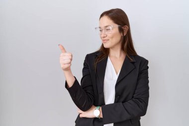 Güzel esmer kadın. İş ceketi ve gözlük takıyor. Gururlu görünüyor, gülümsüyor. 