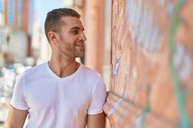 Young caucasian man smiling confident looking to the side at street