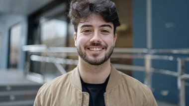 Sokakta kendinden emin gülümseyen İspanyol genç adam.