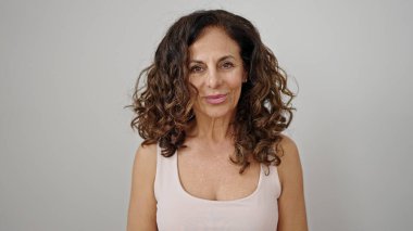 Orta yaşlı İspanyol kadın izole edilmiş beyaz arka planda kendine güvenen gülümsüyor.