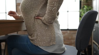 Middle age woman with grey hair business worker suffering for backache at office