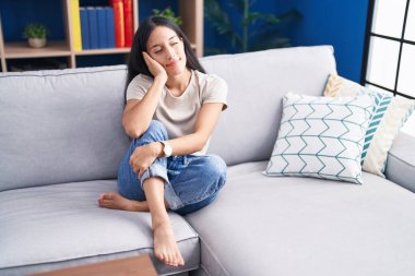 Evdeki kanepede oturan kendine güvenen güzel İspanyol kadın.