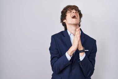 İspanyol iş adamı gözlüklü genç adam elleri bağlı yalvarıyor ve dua ediyor yüzünde umut ifadesi var çok duygusal ve endişeli. Yalvarıyor. 