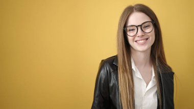 Young blonde woman smiling confident standing over isolated yellow background