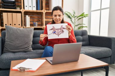 Middle age hispanic woman psychologist having online rorscharch test session at psychology center