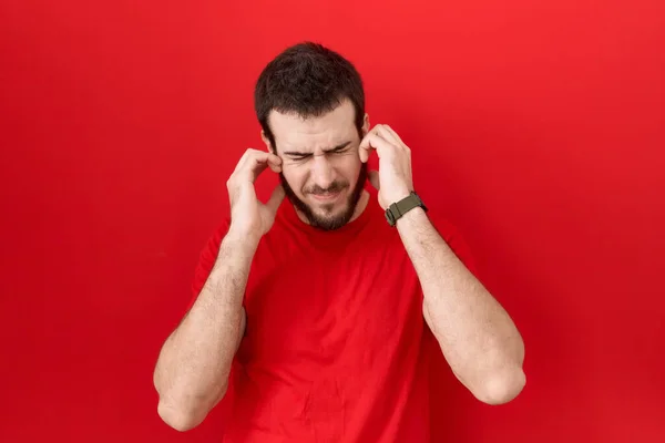 Young Hispanic Man Wearing Casual Red Shirt Covering Ears Fingers — Stock Photo, Image