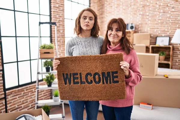 Mother Daughter Holding Welcome Doormat Relaxed Serious Expression Face Simple — Stock Photo, Image