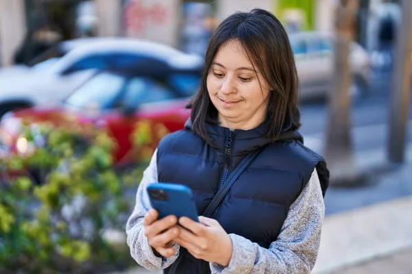 stock image Young woman with down syndrome smiling confident using smartphone at street