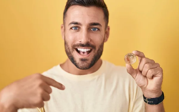 Schöner Hispanischer Mann Mit Kryptowährungsmünze Der Mit Dem Finger Auf — Stockfoto