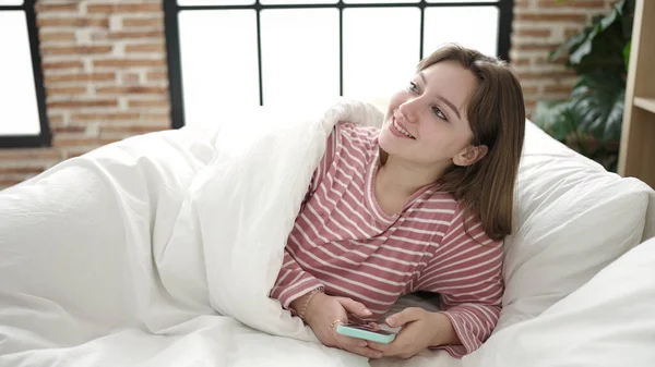 Νεαρή Ξανθιά Γυναίκα Που Χρησιμοποιεί Smartphone Ξαπλωμένη Στο Κρεβάτι Στο — Φωτογραφία Αρχείου