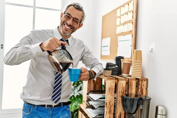 中世の白髪のサラリーマンがオフィスでコーヒーを注ぐ — ストック写真