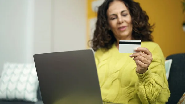 中年惊慌失措的女人坐在家里沙发上 用笔记本电脑和信用卡 — 图库照片
