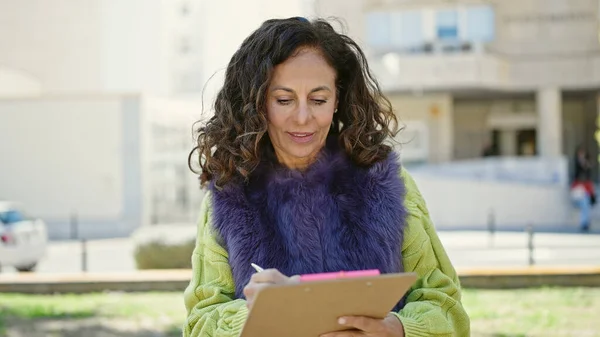 Middle Age Hispanic Woman Smiling Confident Writing Clipboard Park — ストック写真