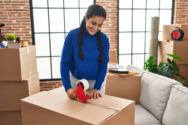 Young Hispanic Woman Smiling Confident Packaging Cardboard Box New Home — Stok fotoğraf
