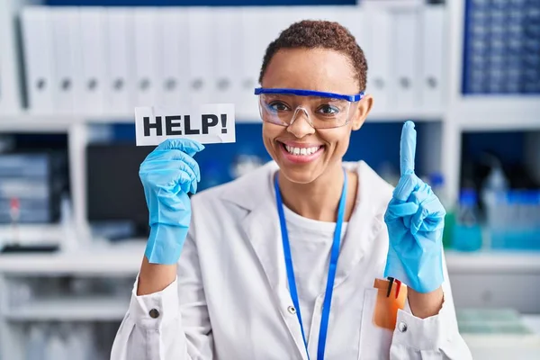 科学研究所で働いている美しいアフリカ系アメリカ人女性は 幸せな顔をしたアイデアや質問を指差す指に驚いて助けを求めています — ストック写真