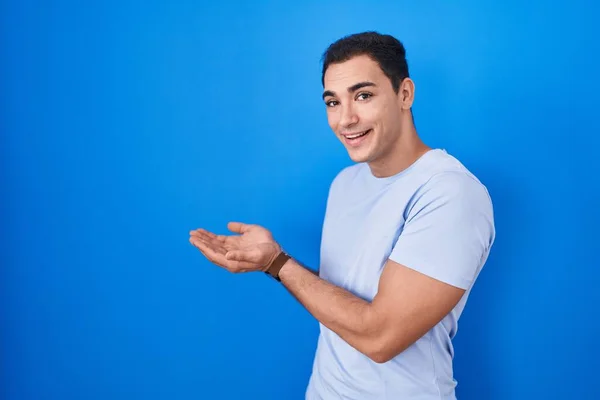 Young Hispanic Man Standing Blue Background Pointing Aside Hands Open — Stock Photo, Image