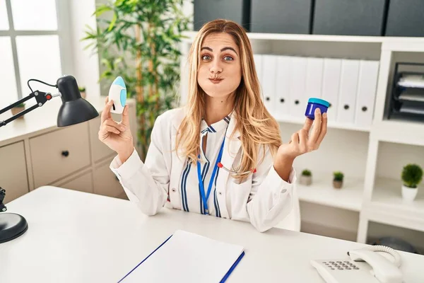 Młoda Blond Lekarz Kobieta Trzyma Produkty Lecznicze Oddychania Lepiej Puffing — Zdjęcie stockowe