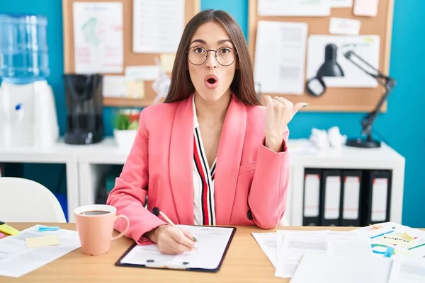 Mujer Hispana Joven Trabajando Oficina Con Gafas Sorprendidas Apuntando Con —  Fotos de Stock