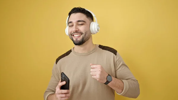 Młody Arabski Człowiek Uśmiecha Się Pewnie Słuchając Muzyki Tańcząc Odizolowanym — Zdjęcie stockowe
