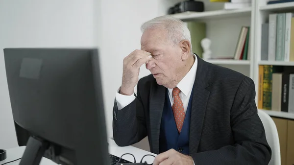 senior university teacher tired using computer at university classroom