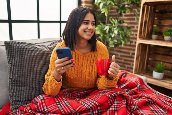Mladá Latinská Žena Pije Kávu Používá Smartphone Doma — Stock fotografie