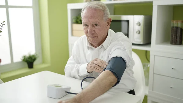 stock image senior measuring pulse using tensiometer at home