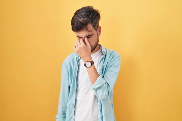 入れ墨を持つ若いヒスパニック系の男は黄色の背景に立って疲れ鼻と目の疲労や頭痛を感じて摩擦 ストレスとフラストレーションの概念 — ストック写真