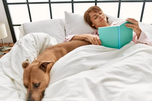 Jovem Caucasiana Leitura Livro Deitado Cama Com Cão Quarto — Fotografia de Stock
