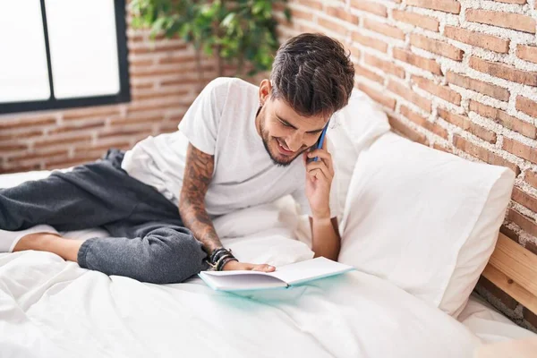 Genç Spanyol Adam Akıllı Telefondan Konuşuyor Yatak Odasında Kitap Yazıyor — Stok fotoğraf