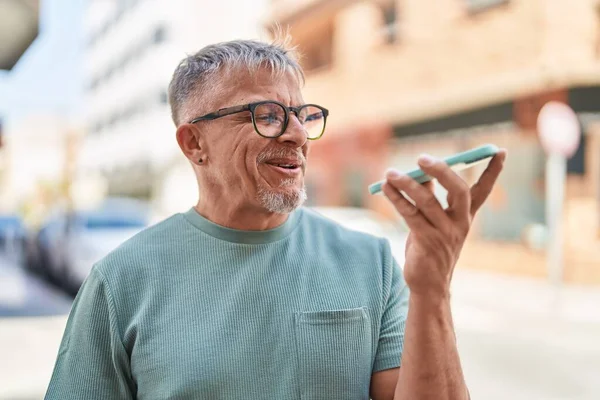中年白发男人在街上用智能手机自信地微笑交谈 — 图库照片