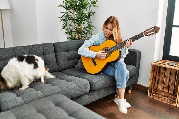 Jovem Caucasiana Tocando Guitarra Clássica Sentada Sofá Com Cão Casa — Fotografia de Stock