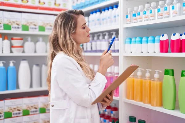 Young Blonde Woman Pharmacist Writing Document Pharmacy — 스톡 사진
