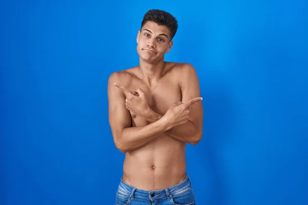 Joven Hombre Hispano Pie Sin Camisa Sobre Fondo Azul Apuntando —  Fotos de Stock