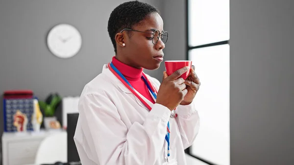 Médico Afroamericano Mujer Oliendo Taza Café Clínica —  Fotos de Stock