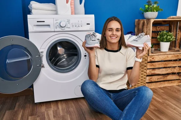 Çamaşır Makinesine Spor Ayakkabısı Koyan Genç Bir Kadın Kameraya Seksi — Stok fotoğraf