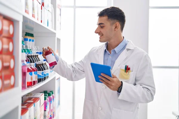 Young Hispanic Man Pharmacist Using Touchpad Holding Medication Bottle Pharmacy — Foto de Stock