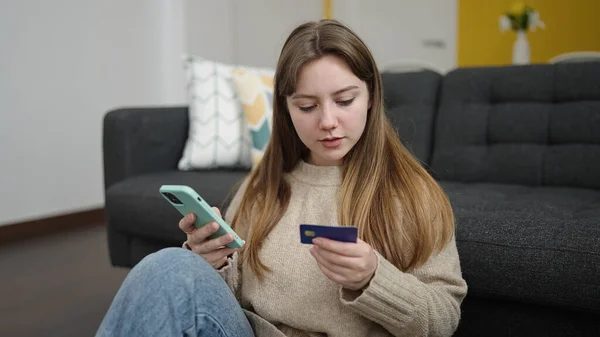 Mladá Blondýna Žena Pomocí Smartphone Kreditní Karty Sedí Podlaze Doma — Stock fotografie