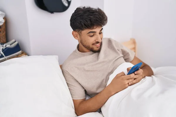Fiatal Arab Férfi Használ Okostelefon Ágyban Hálószobában — Stock Fotó